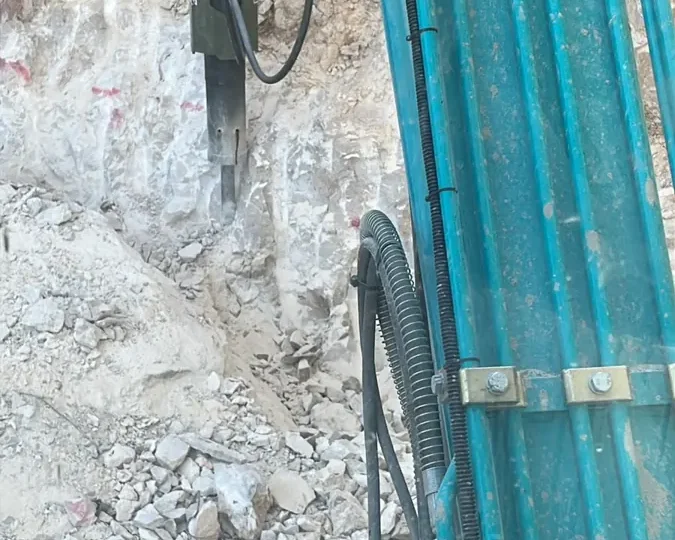 פטיש הידראולי על באגר חוצב בקיר סלע גיר לבן, מבט מתוך תא המפעיל