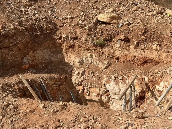 בור חפירה ליסודות בקרקע סלעית: שכבות סלע גיר ואדמה אדומה, עם סמכים ולוחות עץ