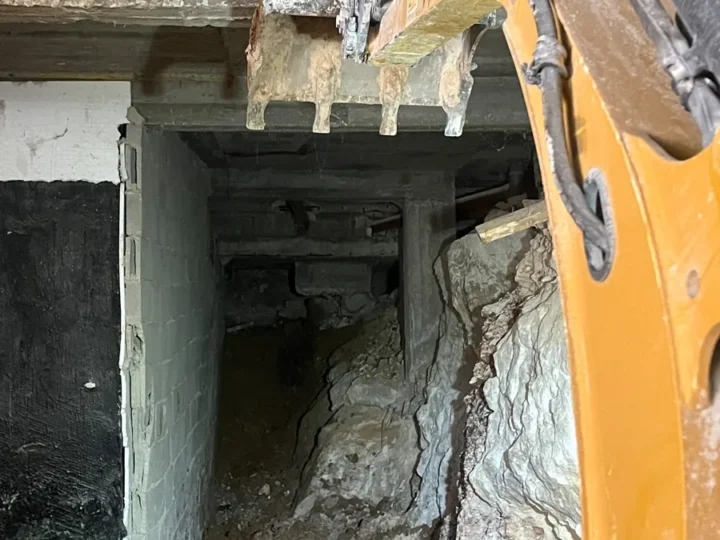 כף מיני מחפרון מתחת לתקרת בטון, חפירת מרתף בסלע מתחת לבית קיים